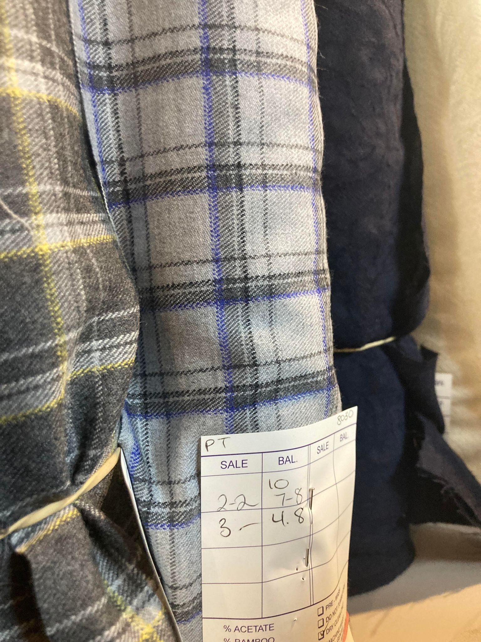 A bolt of grey and blue plaid fabric.